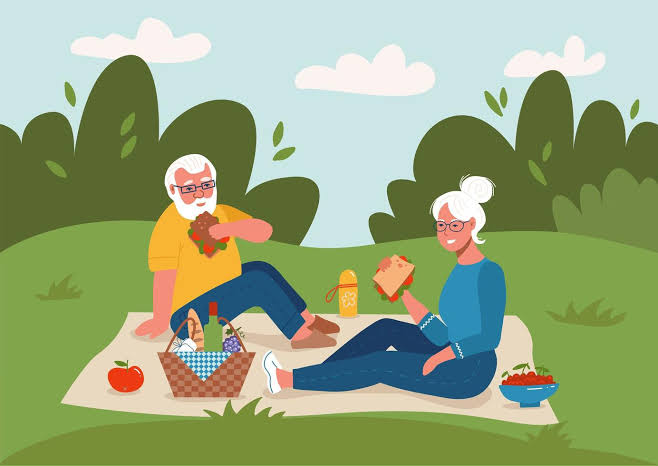 Happy senior couple enjoying an outdoor picnic in a peaceful park setting during retirement
